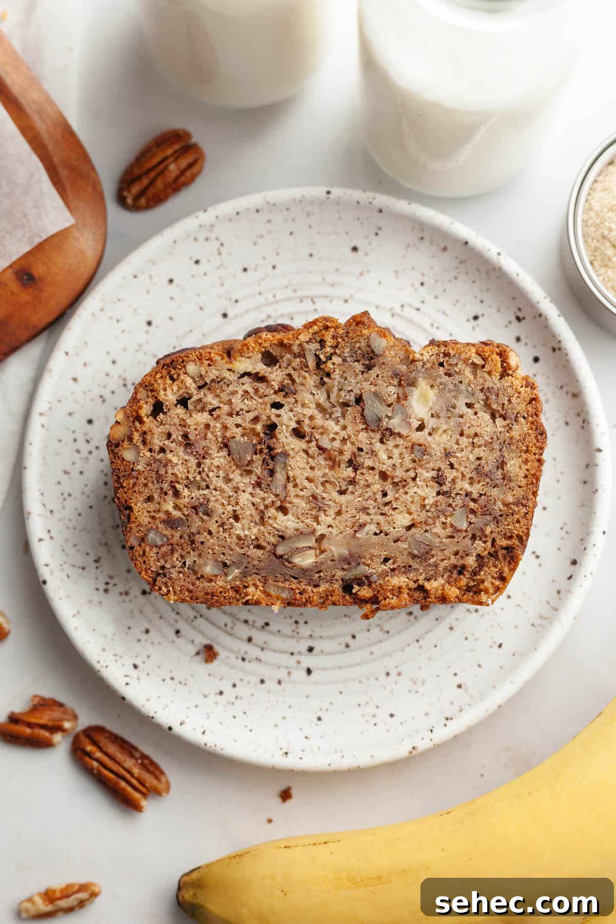 One Bowl Brown Butter Cinnamon Banana Bread with Pecans 11 A slice of banana bread with pecans on a small plate.