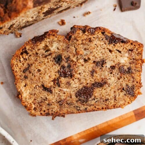 A slice of chocolate chunk banana bread on parchment paper.