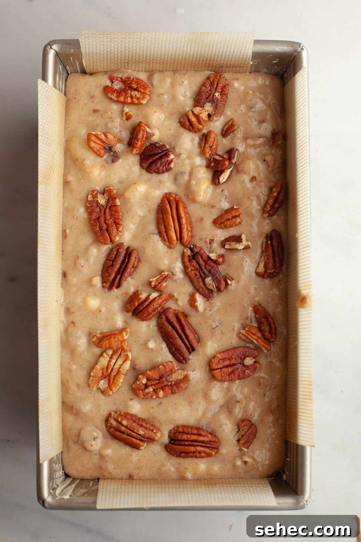 One Bowl Brown Butter Cinnamon Banana Bread with Pecans 8 Unbaked banana bread with pecans in a loaf pan.