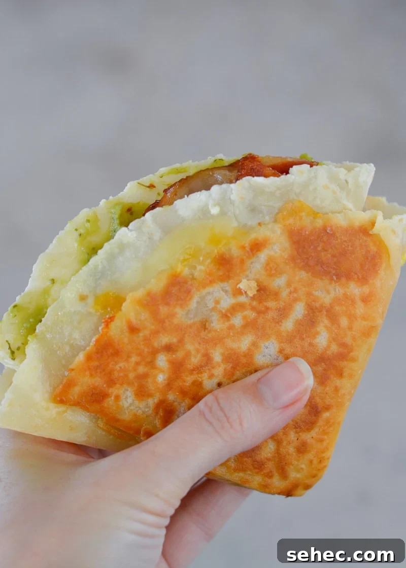 Bacon Egg and Cheese Tortilla Breakfast Wrap 2 Bacon Egg and Cheese Tortilla with fluffy eggs, bacon, cheddar cheese and avocado folded into a crispy breakfast wrap.
