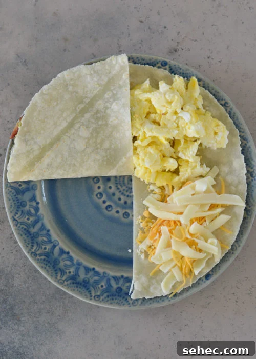 Bacon Egg and Cheese Tortilla Breakfast Wrap 4 Folded bacon egg and cheese tortilla ready to be toasted.