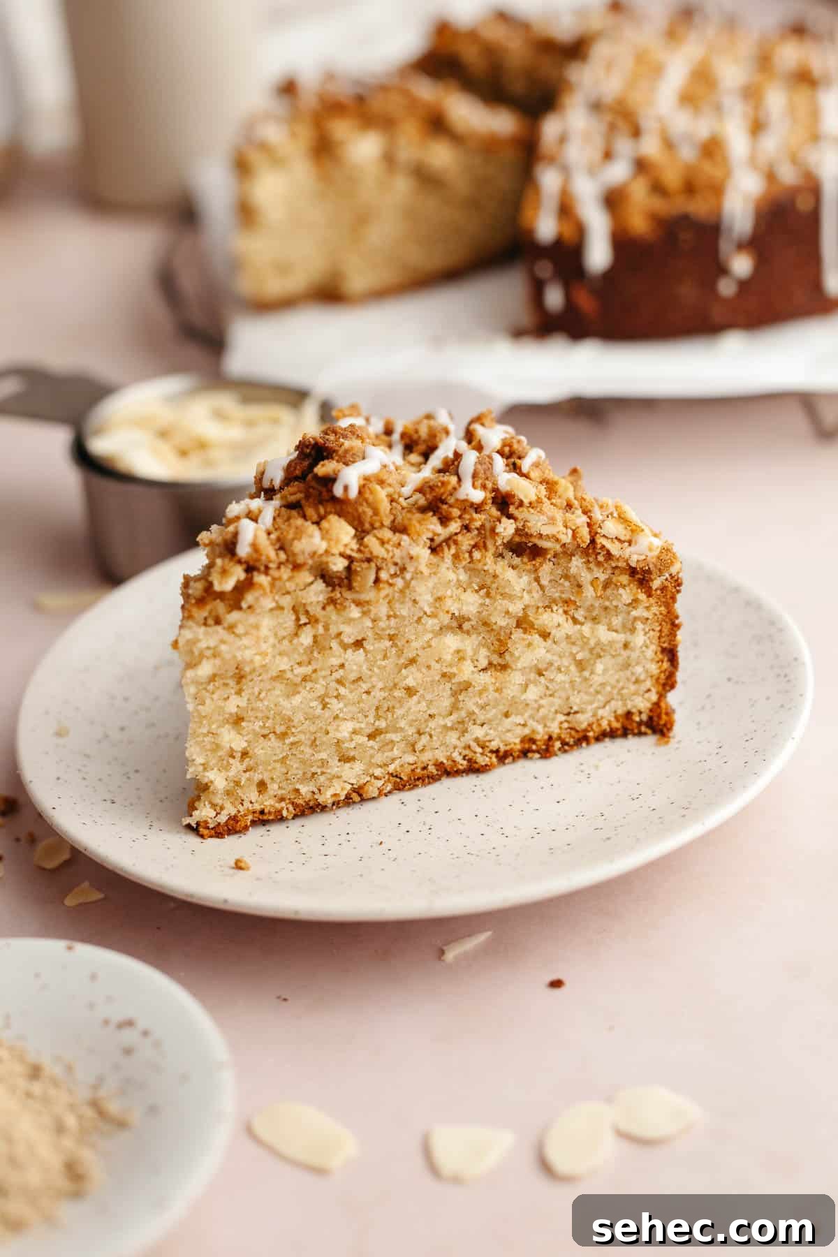 Brown Butter Cardamom Almond Cake Recipe 2 A slice of cardamom almond cake on a small plate, drizzled with a glaze.