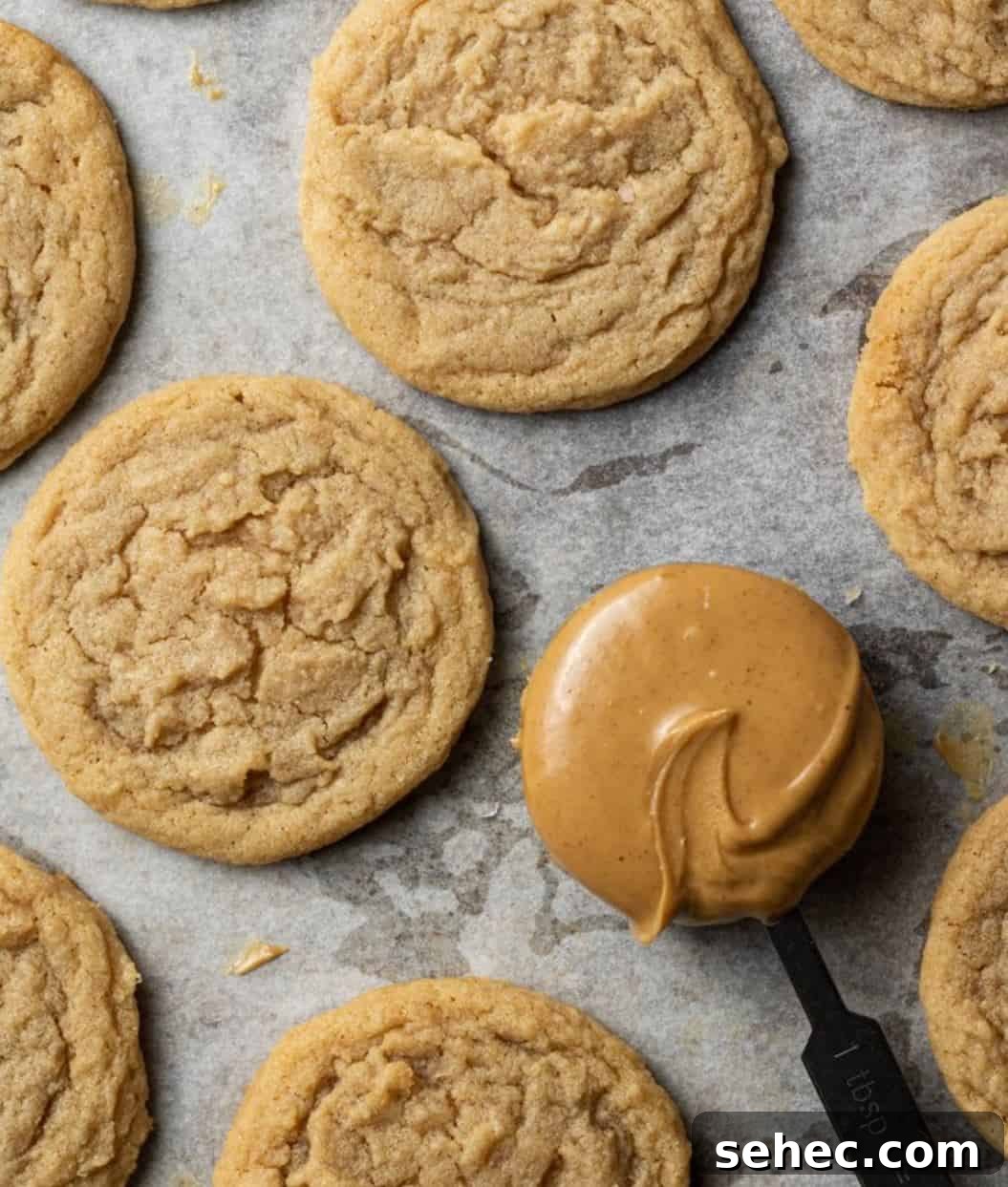 19 Big Batch Cookie Recipes for Parties and Crowds 9 Peanut butter cookies on a counter with a tab;espoon full of peanut butter.