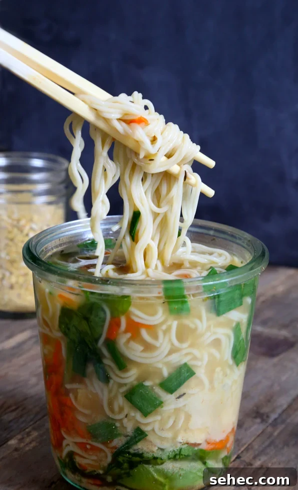 Gluten Free Ramen Recipe with Rich Broth 2 A close up of a mason jar of soup, with chopsticks and noodles.