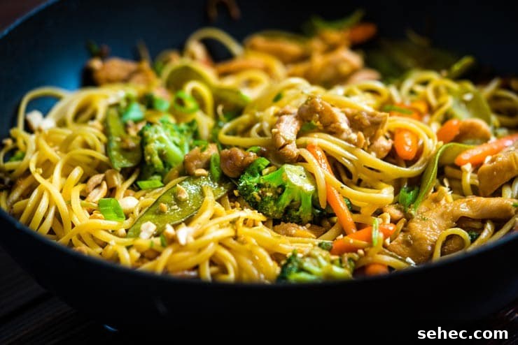 Sweet Chicken Lo Mein Recipe with Tender Noodles 4 Chicken Lo Mein Recipe in wok with broccoli, carrots and peas