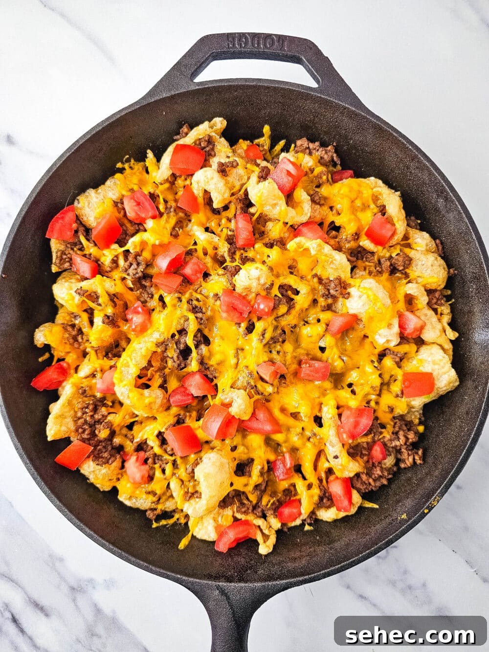 Cast Iron Skillet Pork Rind Nachos 11 Pork rind nachos with tomatoes in a cast iron skillet