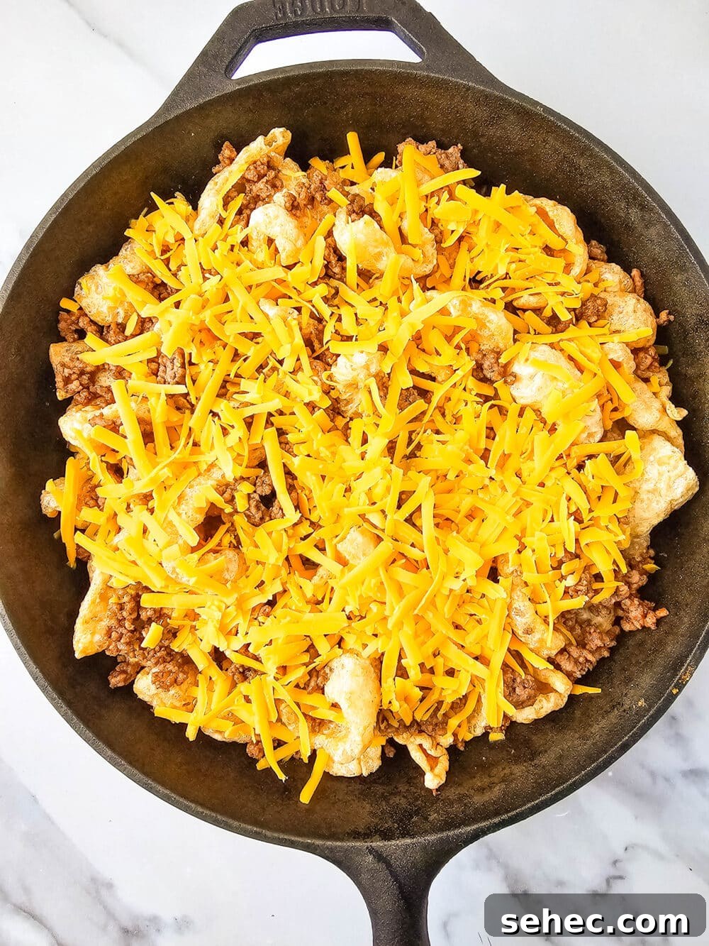 Cast Iron Skillet Pork Rind Nachos 10 Pork rinds, ground beef, and cheese in a cast iron skillet