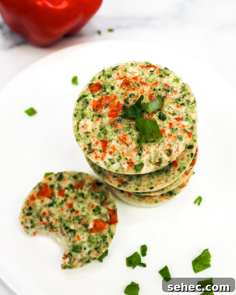 25 High Protein Low Carb Breakfast Ideas for Busy Mornings 4 keto egg bites on a white plate with a bell pepper in the background, one bite taken out of one egg bite
