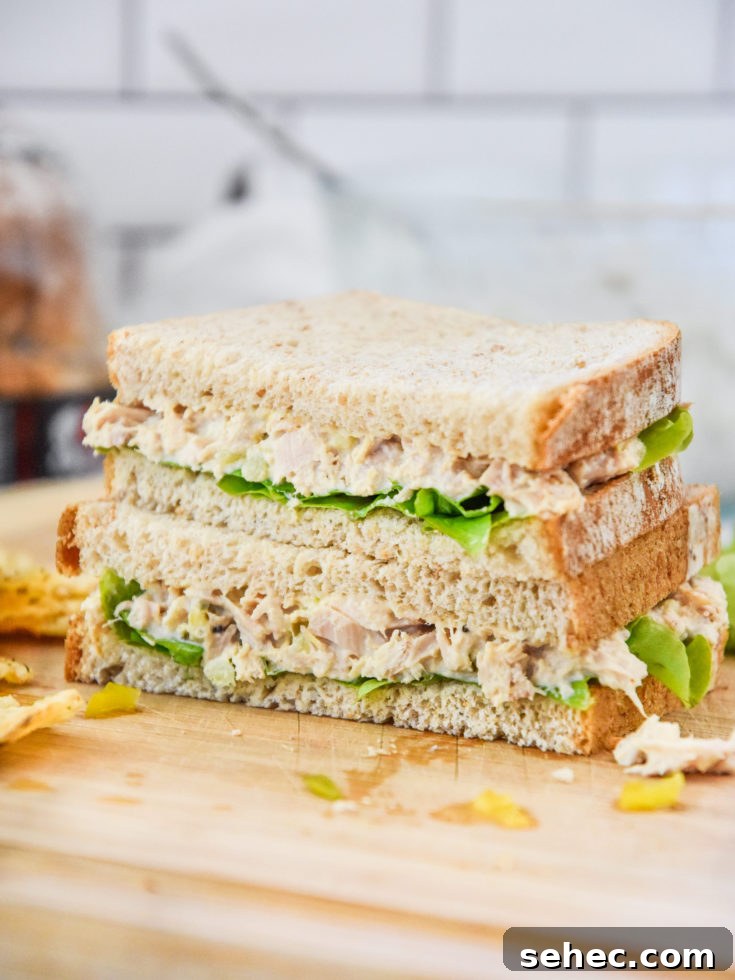 lazy no chop tuna salad sandwich cut in half on a cutting board.