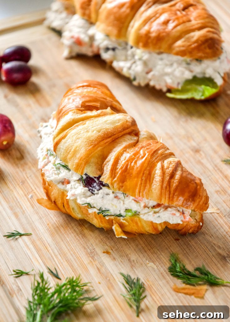 easy chicken salad with grapes on a croissant on a cutting board.