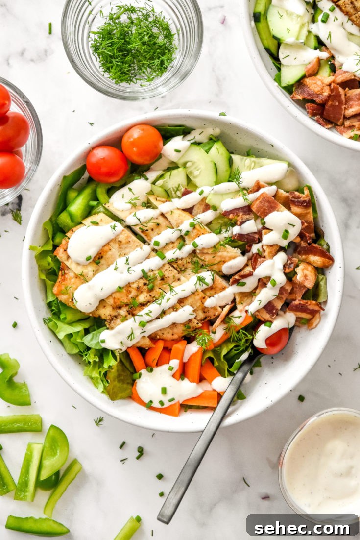 my go-to chicken bacon ranch salad in a white bowl with a fork.