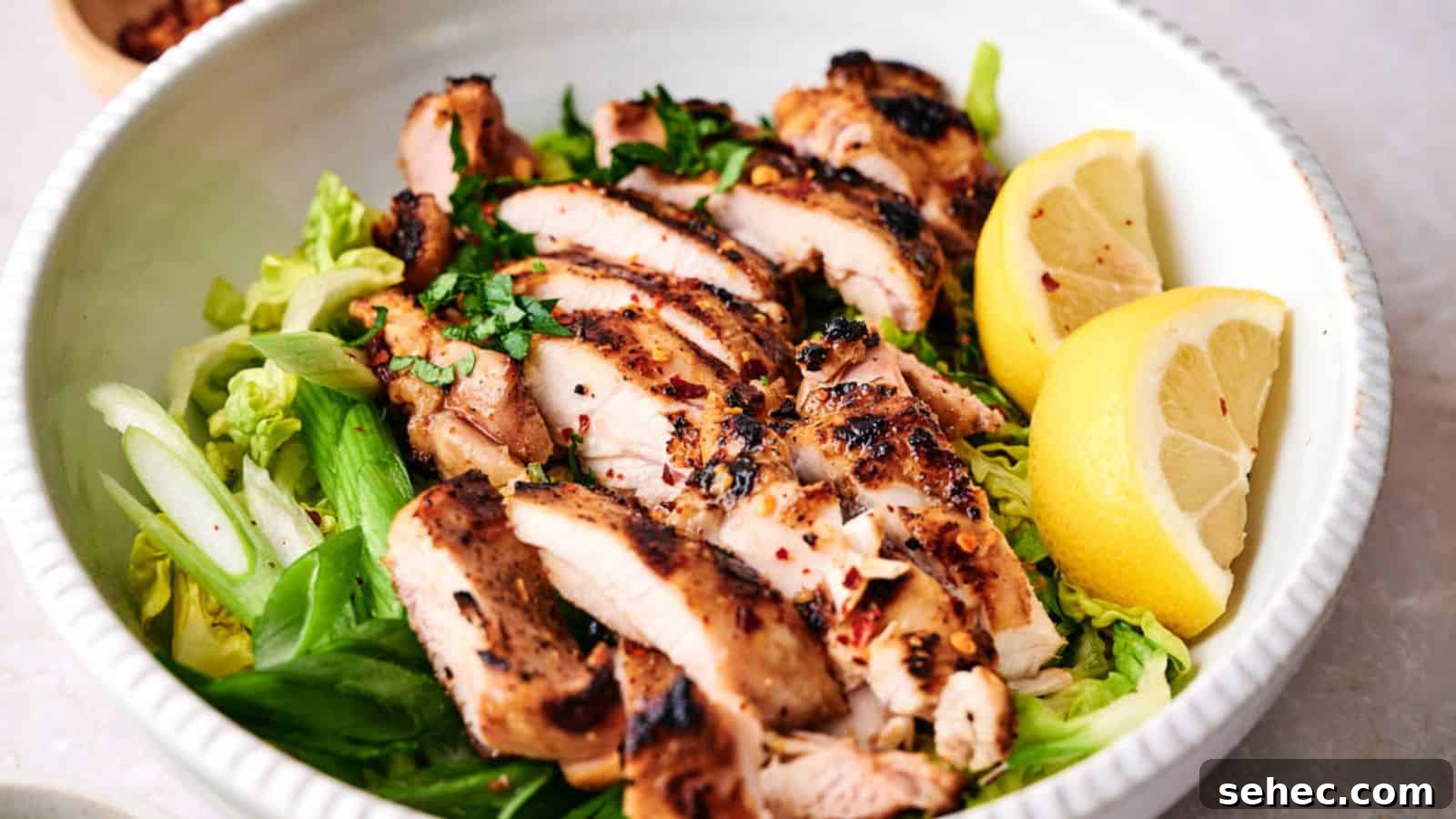 17 Budget Cookout Recipes That Save Room for Better Burgers 6 Grilled chicken breast slices served over a bed of greens with lemon wedges on the side.