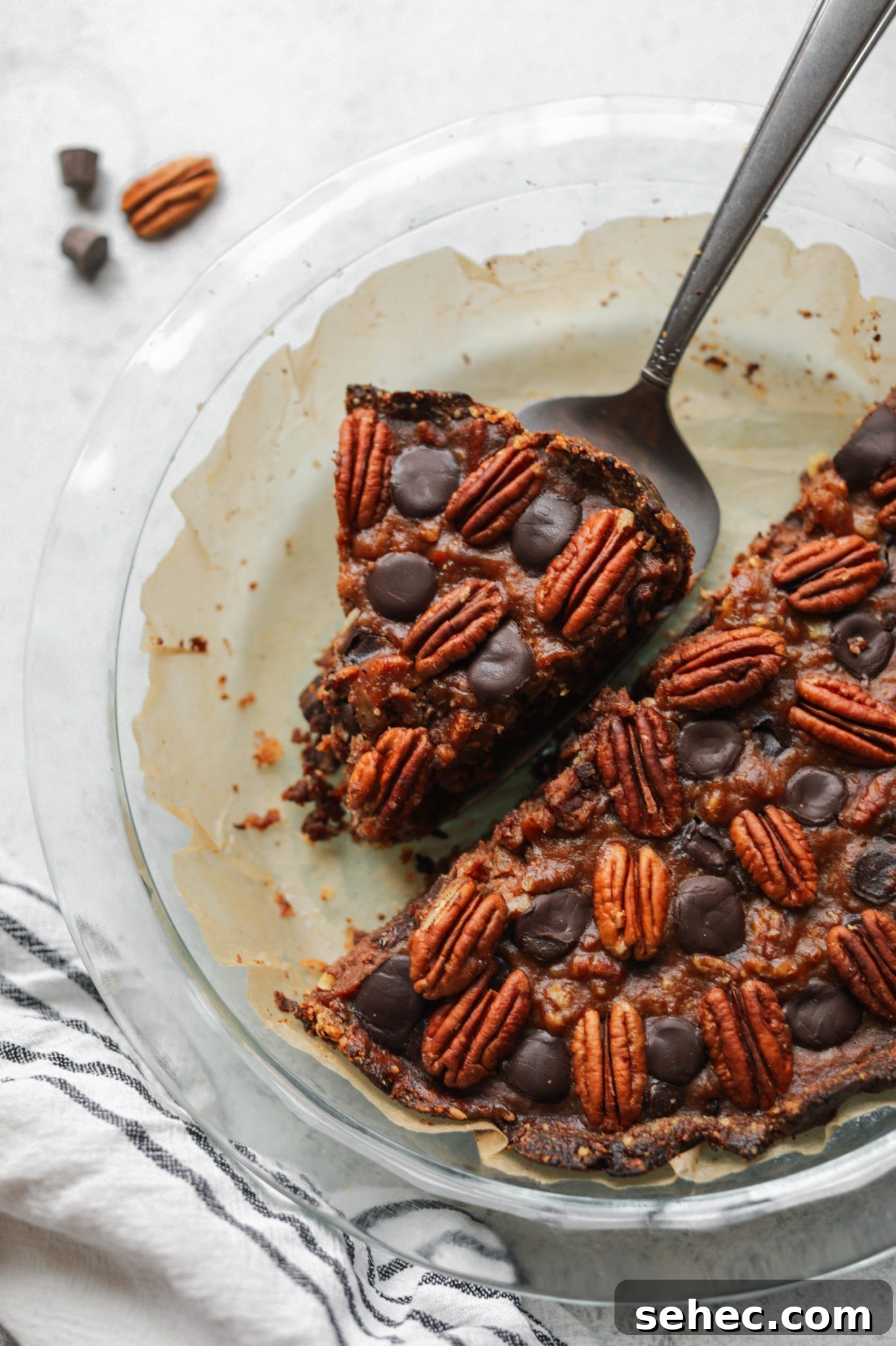 Vegan Dark Chocolate Pecan Pie Recipe 8 Vegan Dark Chocolate Pecan Pie cut with pie server by Flora & Vino