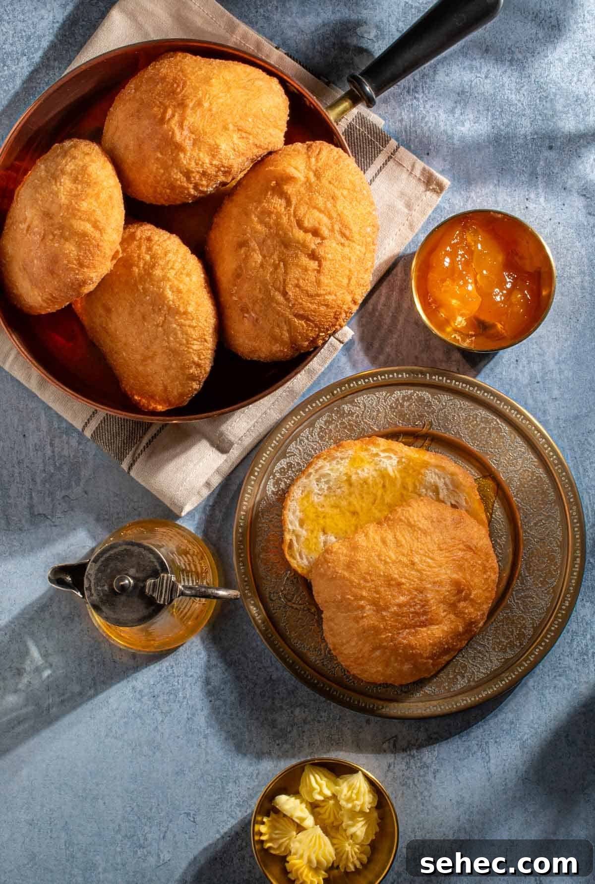 How to Make Authentic South African Vetkoek 2 A bowl of vetkoek next to a plate with one vetkoek, drizzled in golden syrup.