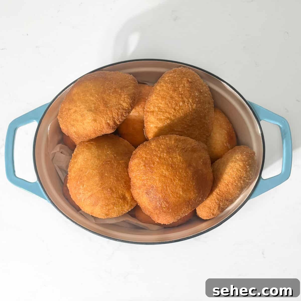 How to Make Authentic South African Vetkoek 10 Cooked vetkoek in a large oval pot.