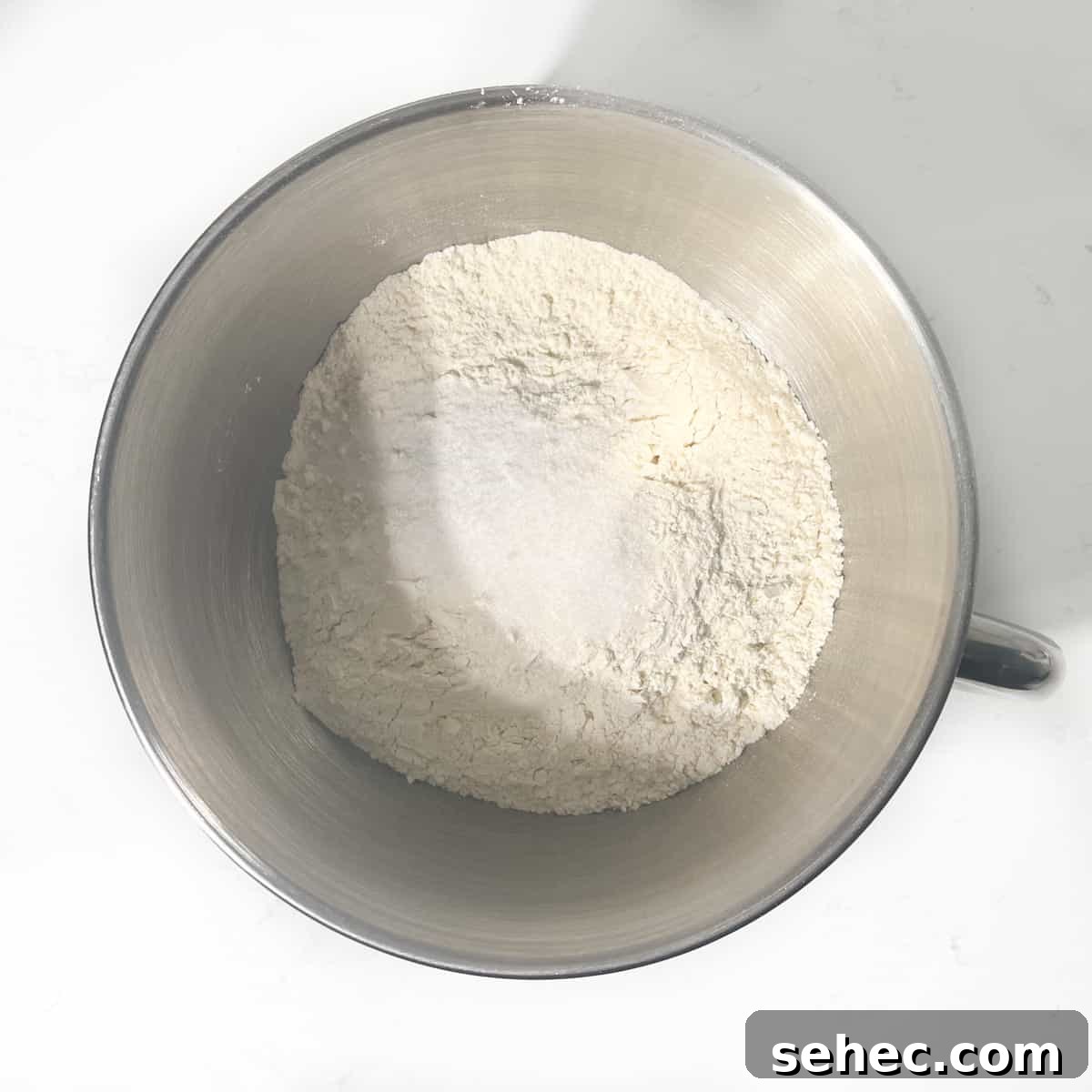 How to Make Authentic South African Vetkoek 5 Adding salt and sugar to flour in a large mixing bowl.