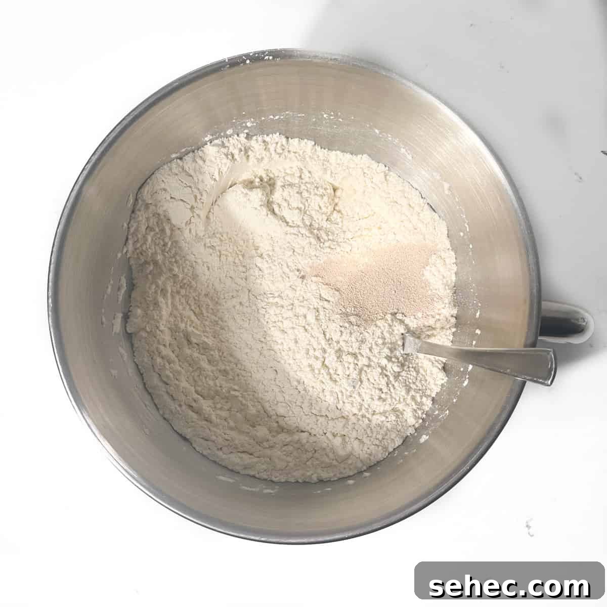 How to Make Authentic South African Vetkoek 6 Adding yeast to flour in a large mixing bow.