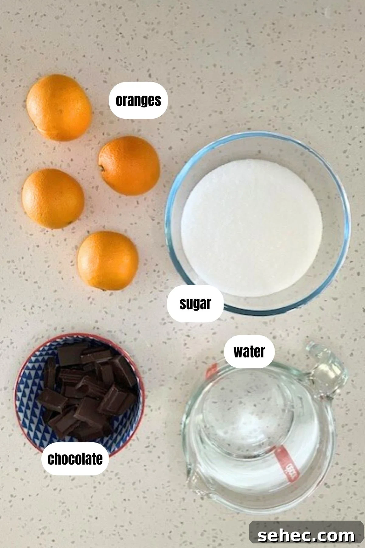 Chocolate Dipped Candied Orange Slices with Gift Tags 3 Labelled overhead image of ingredients for candied orange slices dipped in chocolate, including oranges, water, sugar and chocolate.