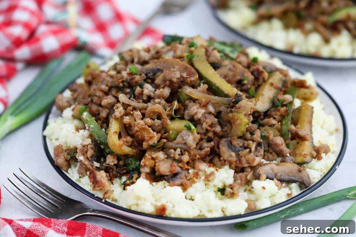 19 Weeknight Dinner Recipes You’ll Want to Cook Again 7 A plate with ground pork and vegetables on top of cauliflower rice.