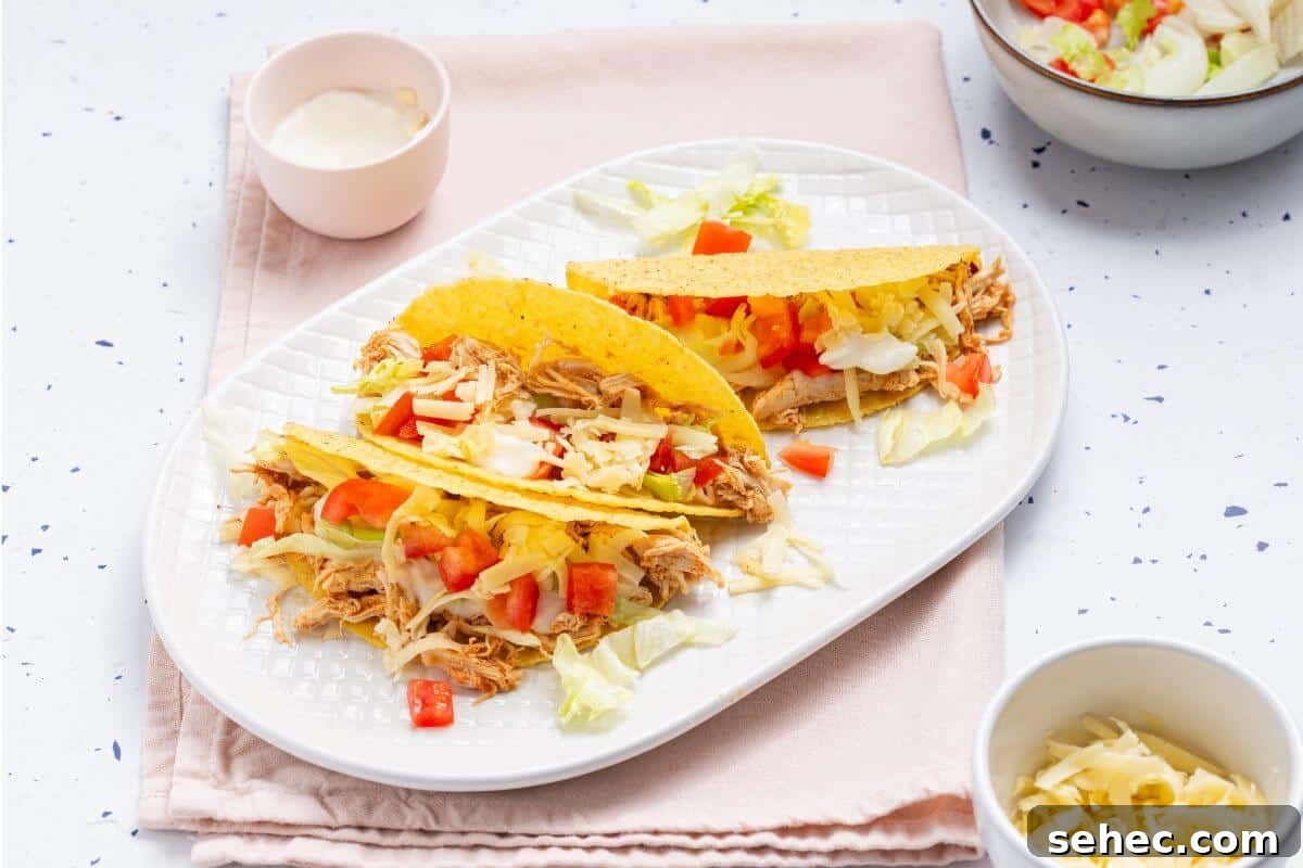 19 Weeknight Dinner Recipes You’ll Want to Cook Again 8 Two tacos on a plate with a bowl of guacamole.