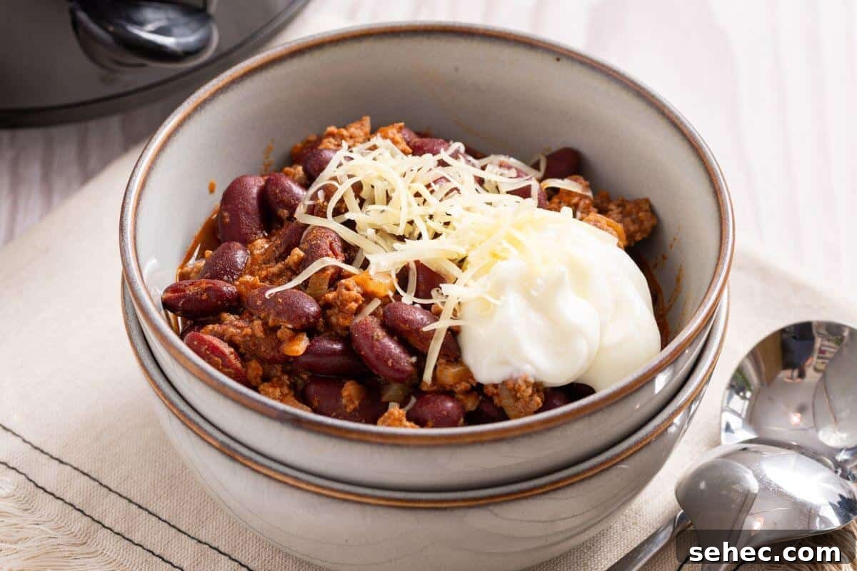 19 Weeknight Dinner Recipes You’ll Want to Cook Again 9 Crock Pot Chili served in two white bowls with spoon.