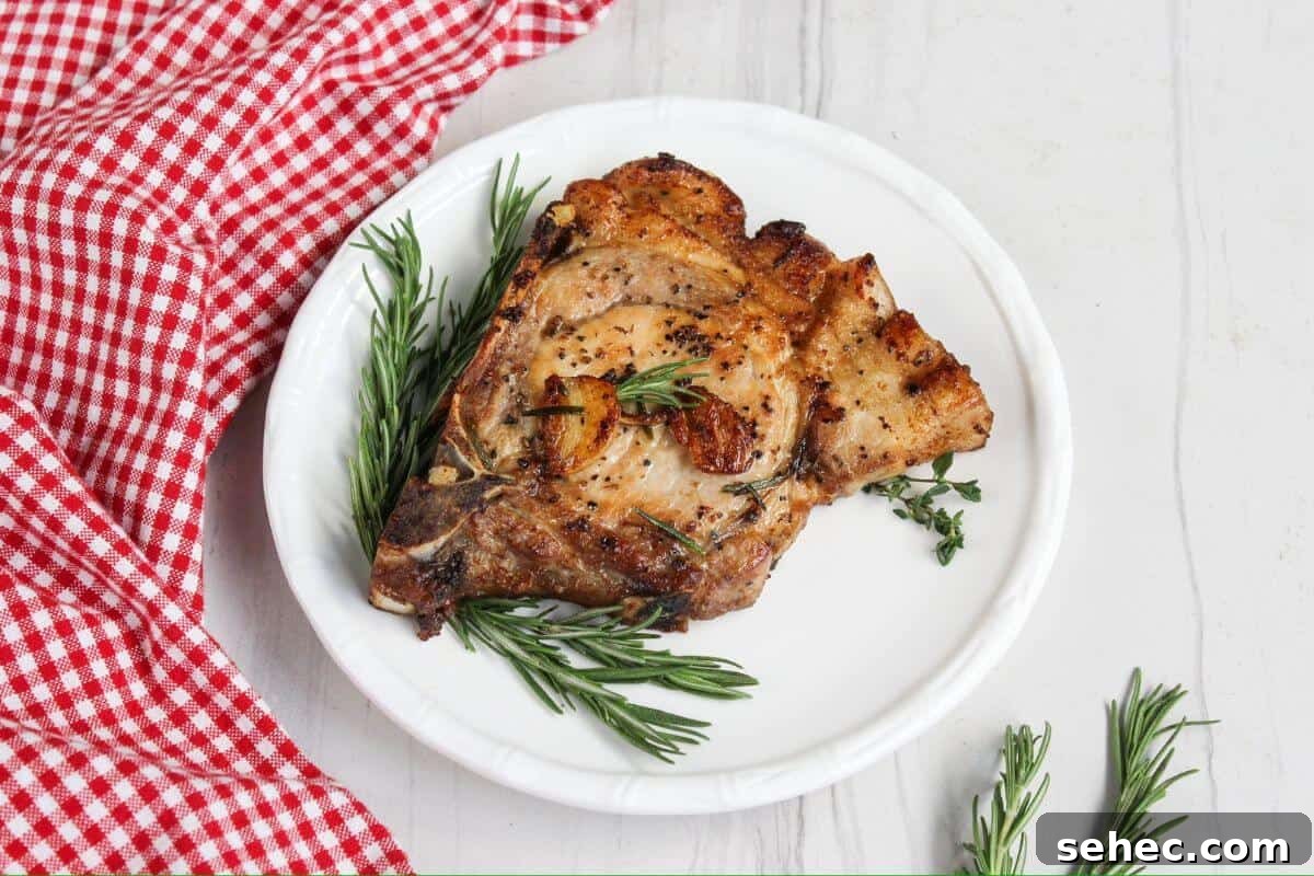 19 Weeknight Dinner Recipes You’ll Want to Cook Again 10 Pork chops on a plate with rosemary sprigs.