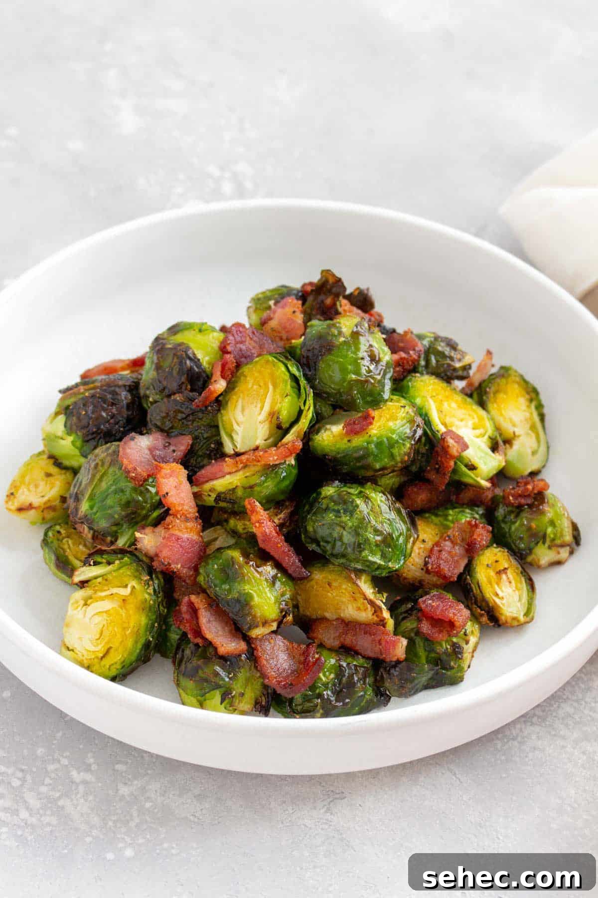 Crispy Air Fryer Brussels Sprouts with Bacon 2 An angled view of a plate of air fryer brussels sprouts and bacon.