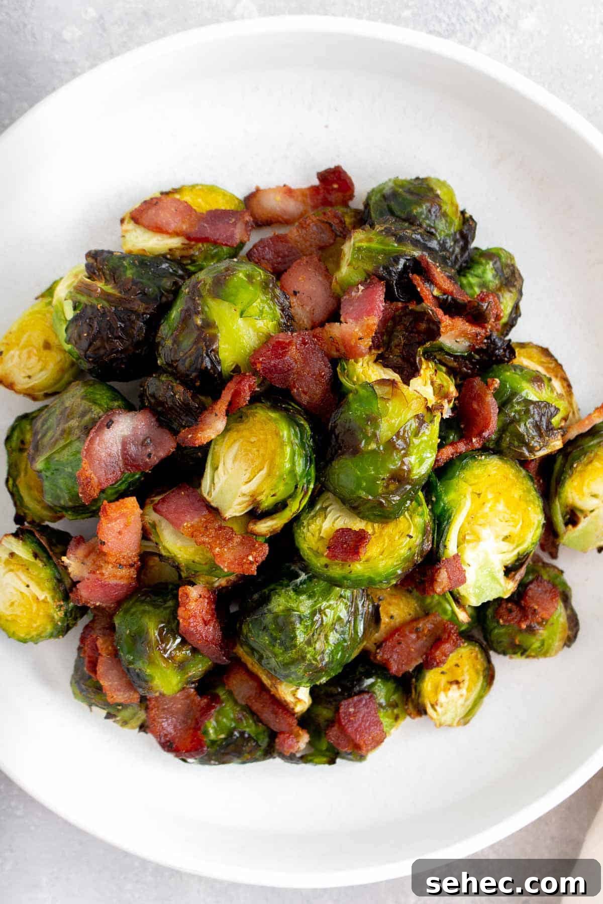 Crispy Air Fryer Brussels Sprouts with Bacon 7 Overhead view of a white plate with air fryer brussels sprouts and bacon.
