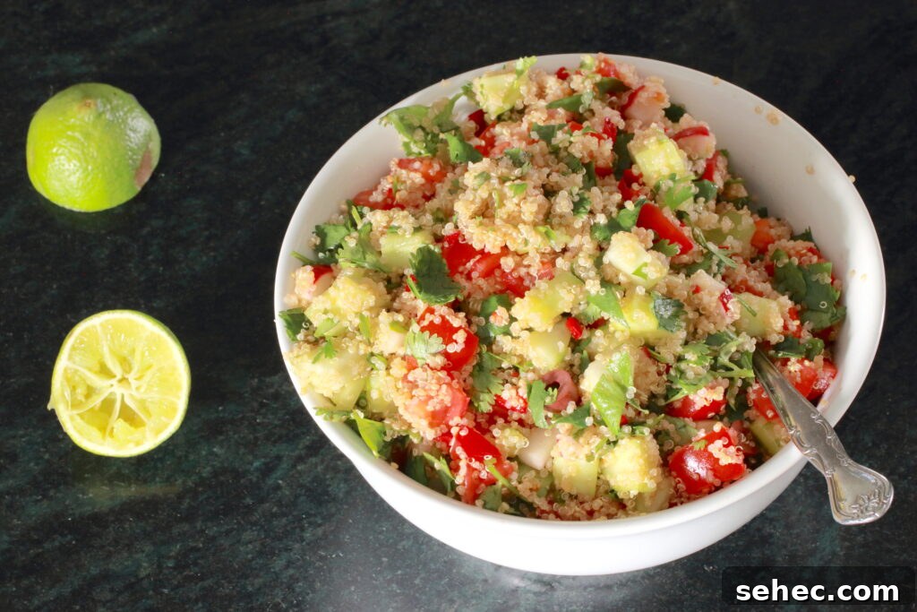 Zesty Quinoa Salad with Lemon Herb Dressing 2 Zesty Quinoa Salad in a white bowl with spoon; halved lemon to the side