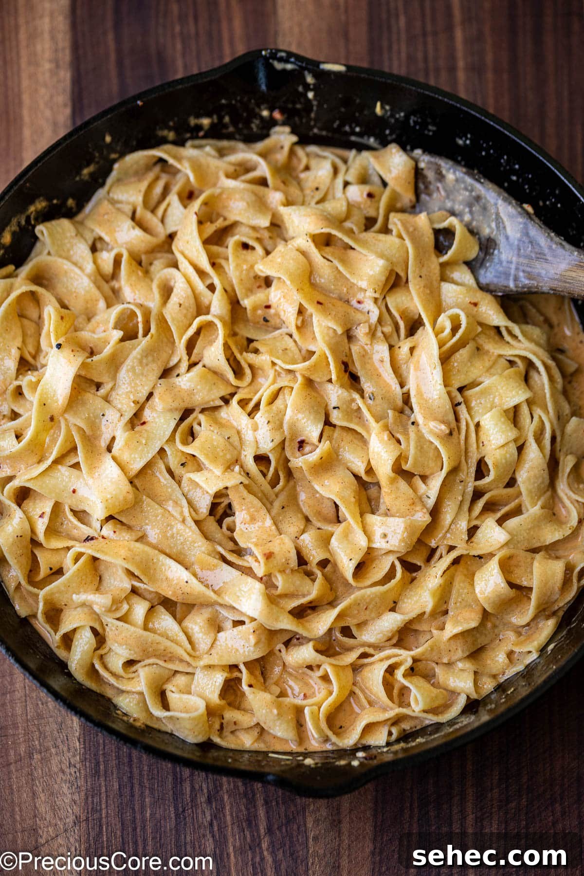Creamy Cajun Salmon Pasta 10 Mixing cooked pasta with homemade sauce.