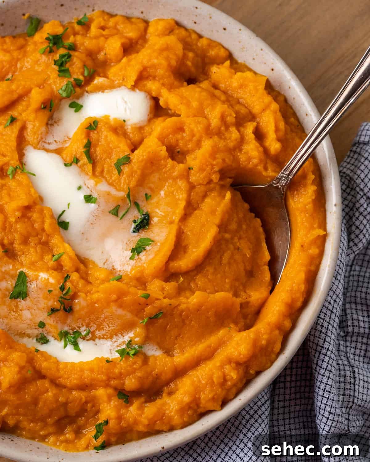 Creamy Instant Pot Mashed Sweet Potatoes 2 A serving spoon scooping into a bowl of mashed sweet potatoes topped with melted butter.