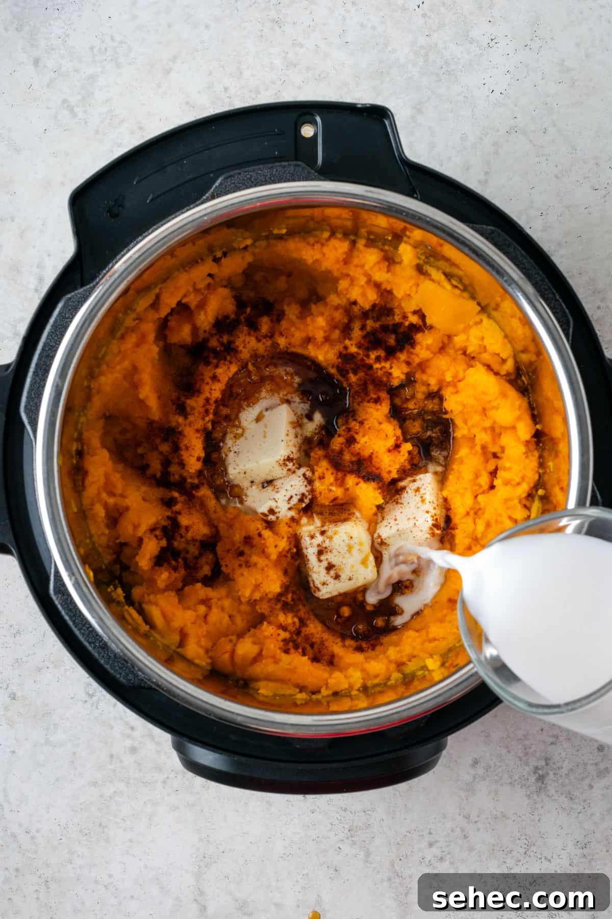 Creamy Instant Pot Mashed Sweet Potatoes 6 Chili powder, maple syrup, butter and milk being added to the sweet potato mash.