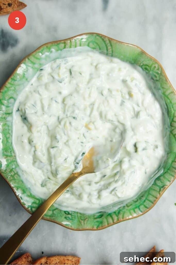 Crispy Smashed Potato Salad with Tzatziki Sauce 7 Spoon in a bowl with tzatziki sauce.
