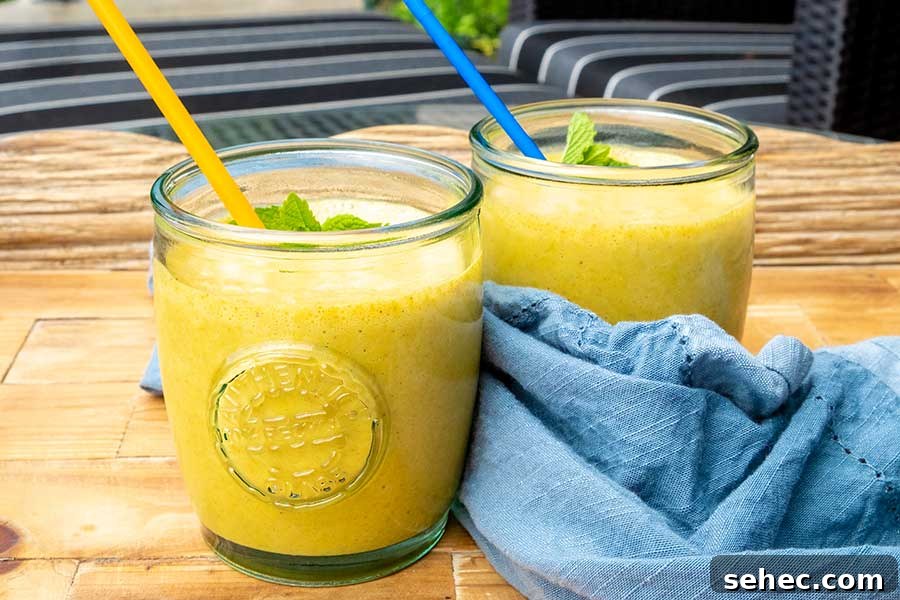 apricot turmeric ginger chia smoothie in a glass with a straw