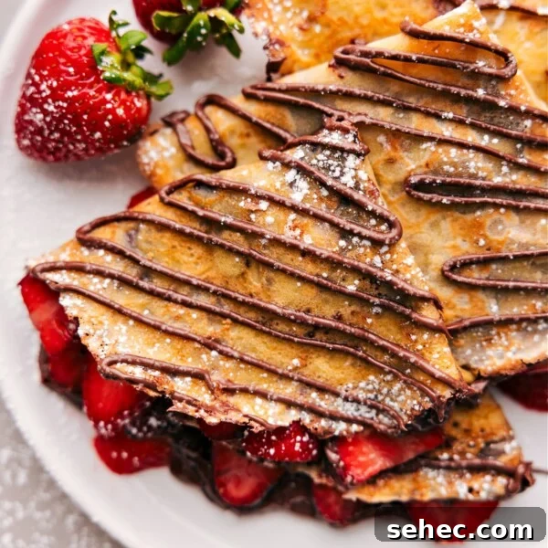 The finished dessert of warm Nutella crepes expertly cooked to achieve the perfect texture, filled with fresh strawberries and Nutella.