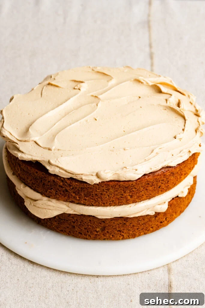 Brown Butter Buttercream Frosting Recipe 3 A two layer cake on a marble plate frosting with brown sugar buttercream.