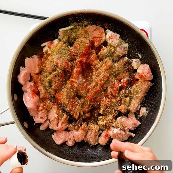 High Protein Loaded Baked Sweet Potato Breakfast 9 Adding seasonings to ground turkey sausage in a skillet.