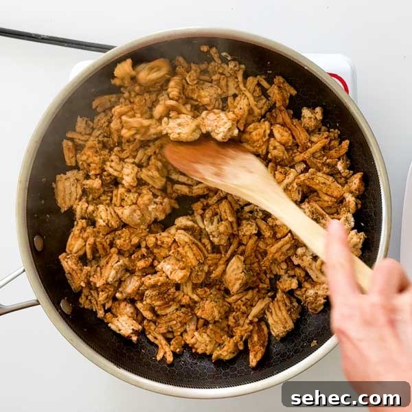 High Protein Loaded Baked Sweet Potato Breakfast 10 Mixing ground turkey sausage with a spatula.