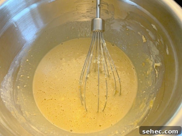 Gluten-Free Peanut Butter Donuts Recipe 6 The wet donut ingredients in a bowl with a whisk.