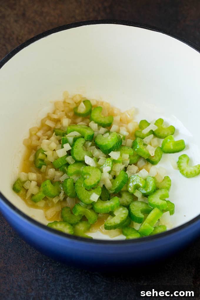 Onion and celery cooking in butter for soup Sauteed celery and onions in a pot.
