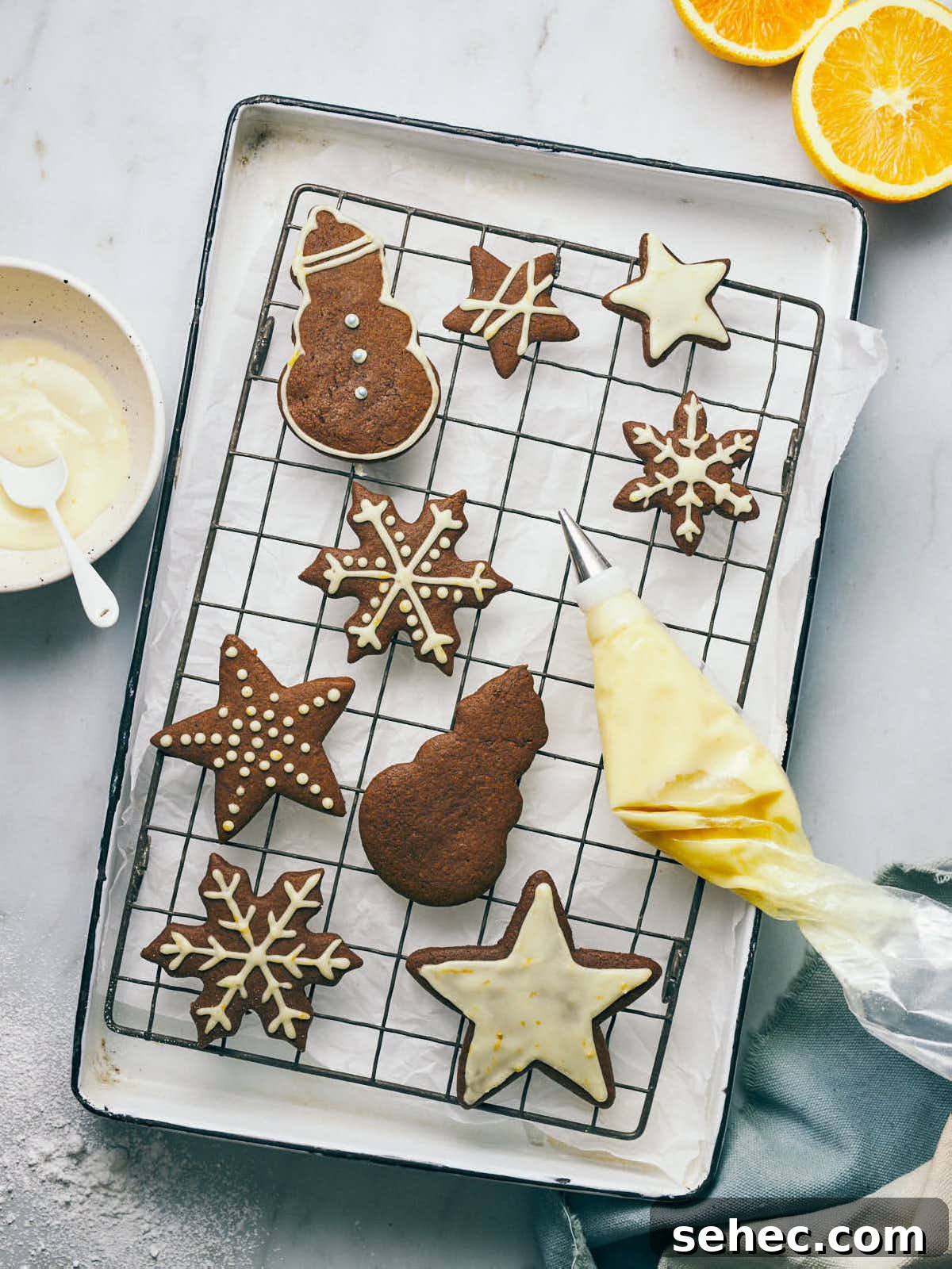 Gingerbread cookies on a cooling rack with orange icing piping bag