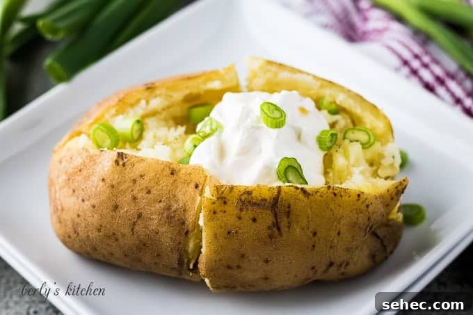 Instant Pot Baked Potatoes in 30 Minutes 2 The baked potato on a plate with chives and sour cream.