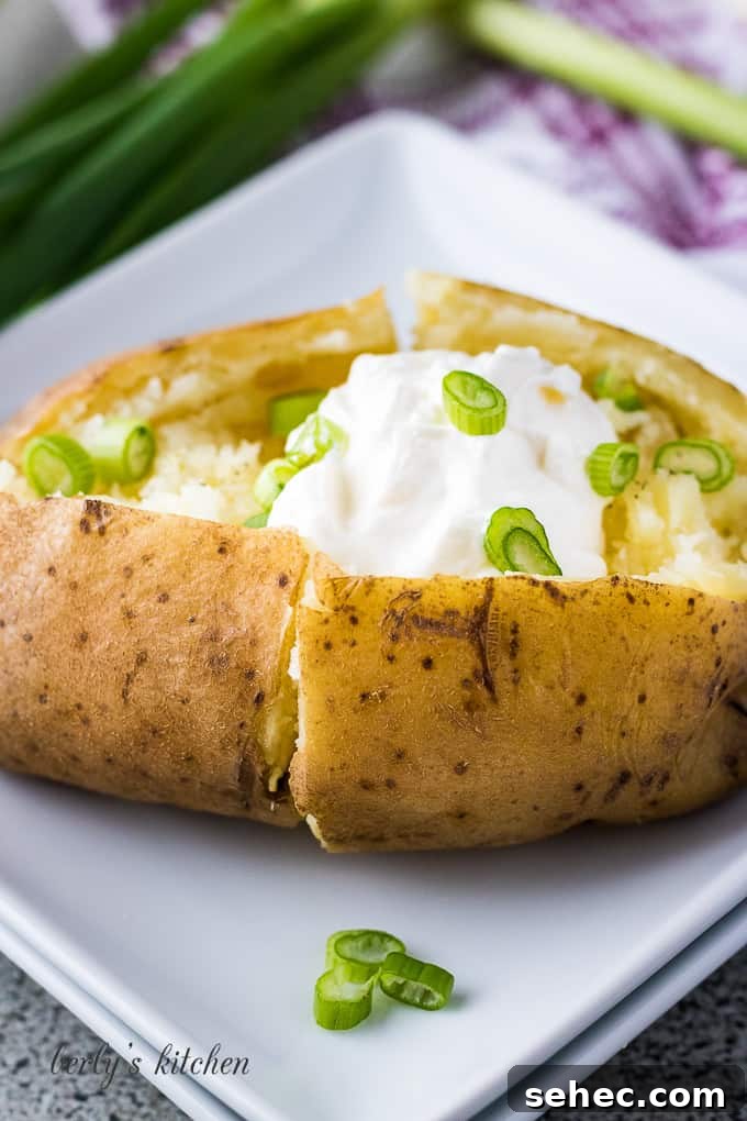 Instant Pot Baked Potatoes in 30 Minutes 4 Instant Pot Baked Potatoes on a plate with sour cream and chives.