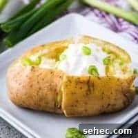 Instant Pot Baked Potatoes in 30 Minutes 5 The cooked potato topped with sour cream, butter, and onions.