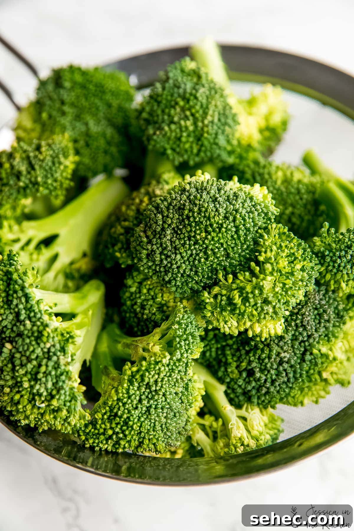 Vegan Bang Bang Broccoli with Creamy Spicy Sauce 3 Close up shot of raw broccoli in a metal strainer.