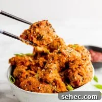Vegan Bang Bang Broccoli with Creamy Spicy Sauce 6 Bang bang broccoli being held by chopsticks over a bowl with more broccoli in it.