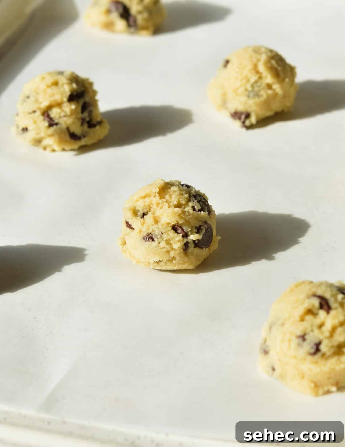 Chewy Almond Flour Chocolate Chip Cookies 12 cookie dough balls on a sheet pan.