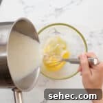 Boston Cream Pie Donuts with Chocolate Glaze 15 tempering eggs with cream in a glass bowl.