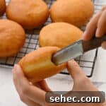 Boston Cream Pie Donuts with Chocolate Glaze 22 hollowing out a donut with a knife.