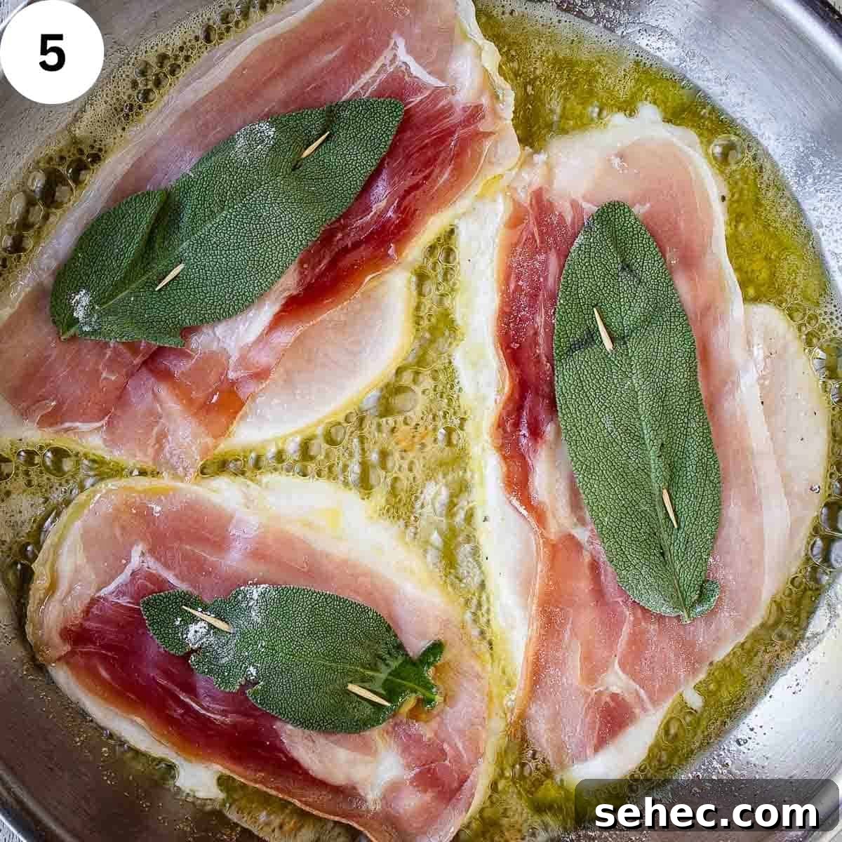 Chicken Saltimbocca with Prosciutto and Sage 8 Three chicken cutlets with prosciutto and a sage leaf frying in a pan.